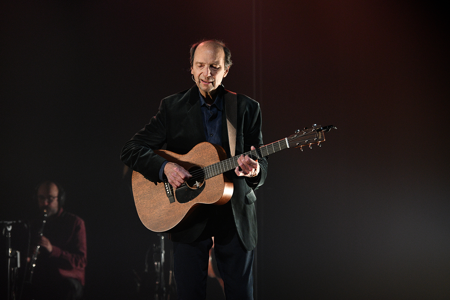 Michel Rivard habillé en noir sur la scène